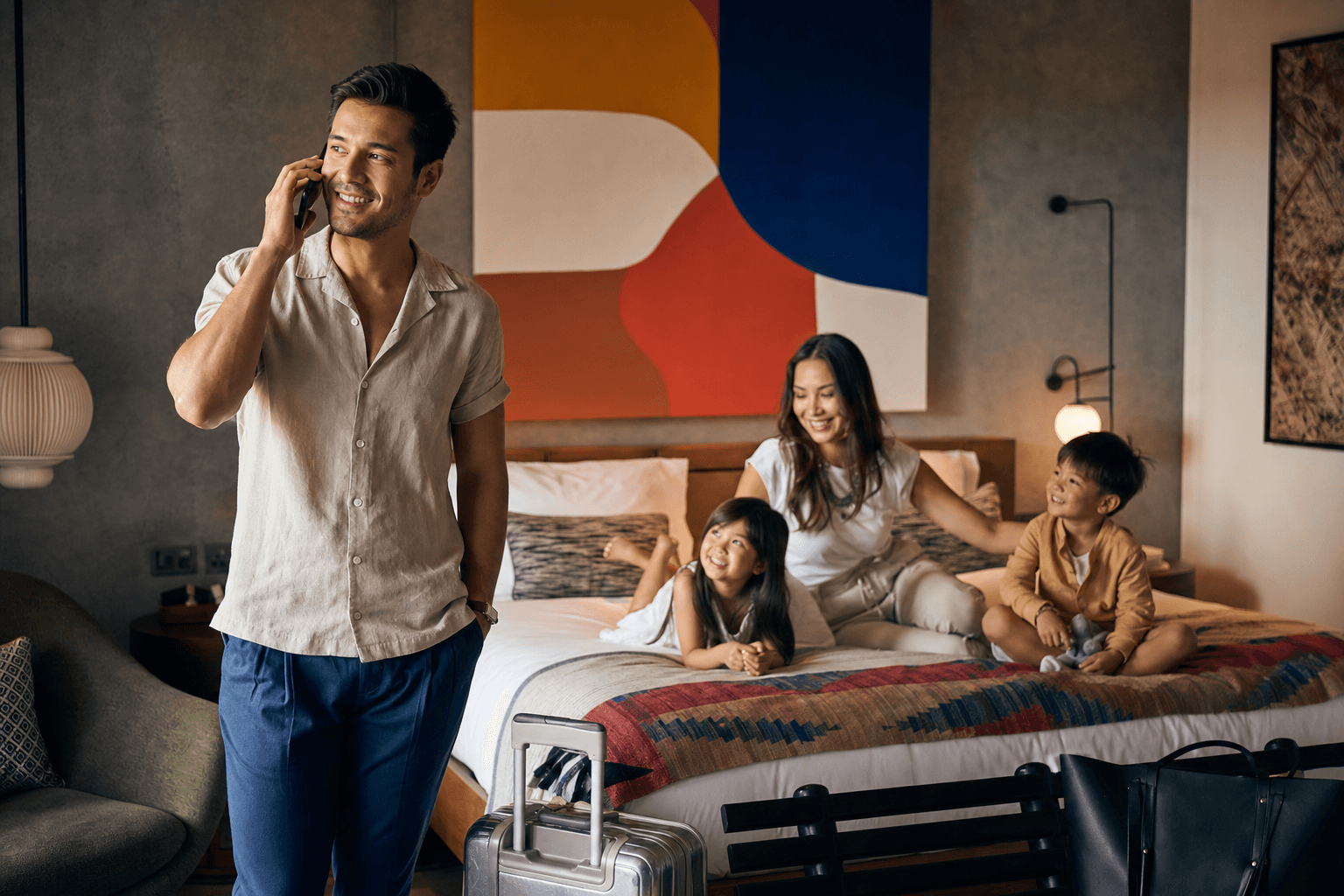 Family in a stylish hotel room, the father on the phone arranging an airport pickup