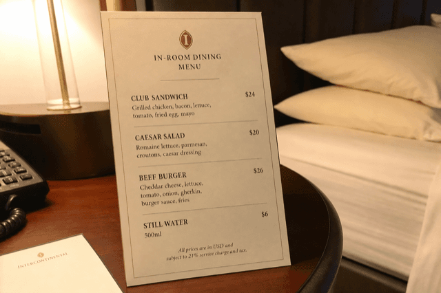 Speisekarte für In-Room-Dining auf dem Nachttisch mit Club-Sandwiches, Burgern und Salaten