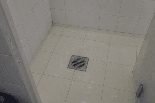 Gemeinschaftsdusche mit stehendem Wasser um den Ablaufrrost